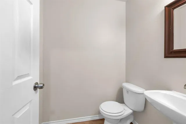 a white toilet sitting next to a white wall