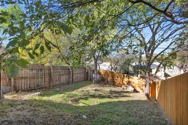 a view of a yard with wooden fence