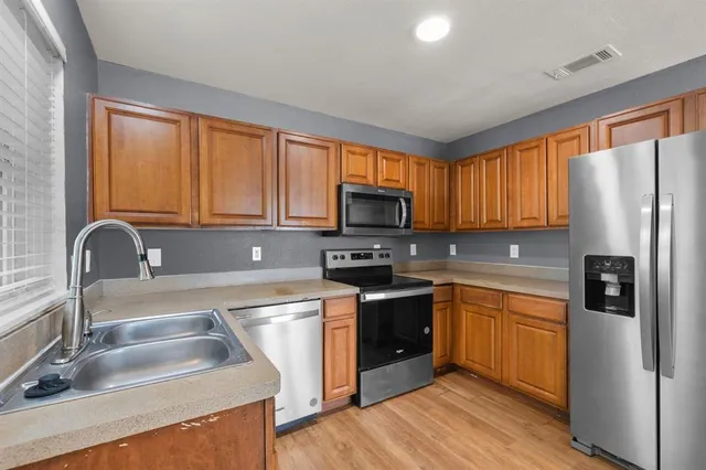 a kitchen with stainless steel appliances granite countertop a refrigerator sink and microwave