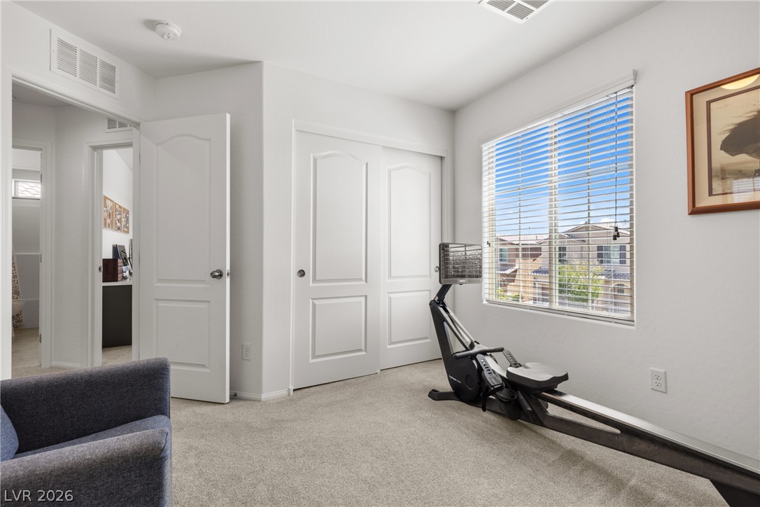 891 Earth Luster Road Las Vegas, NV 89178 - Photo 21 of 48 A versatile room with soft carpeting, a window offering neighborhood views, and convenient sliding closet doors.