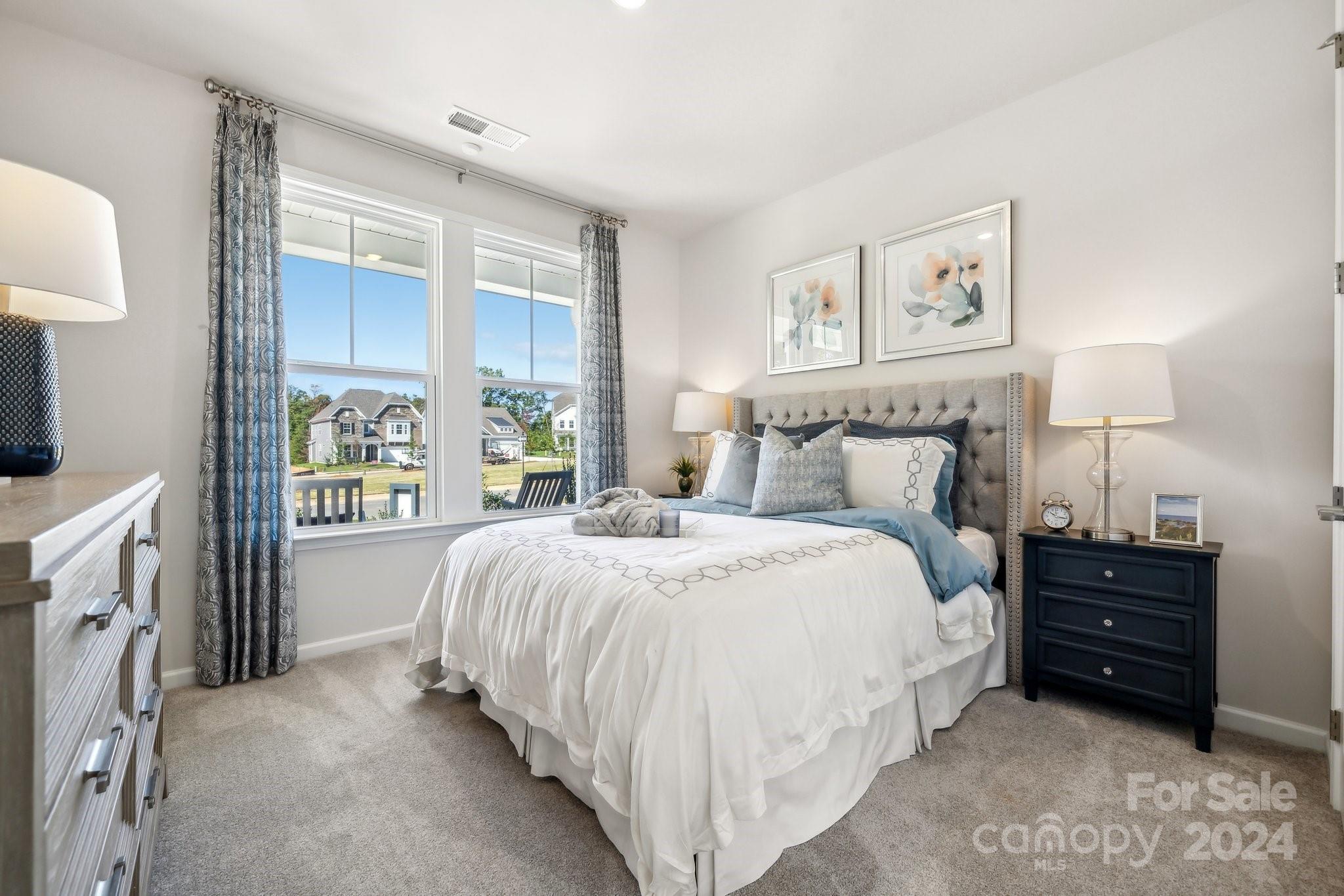 1406 Hubert Graham Way Tega Cay, SC 29708 - Photo 11 of 26 a spacious bedroom with a bed and a window