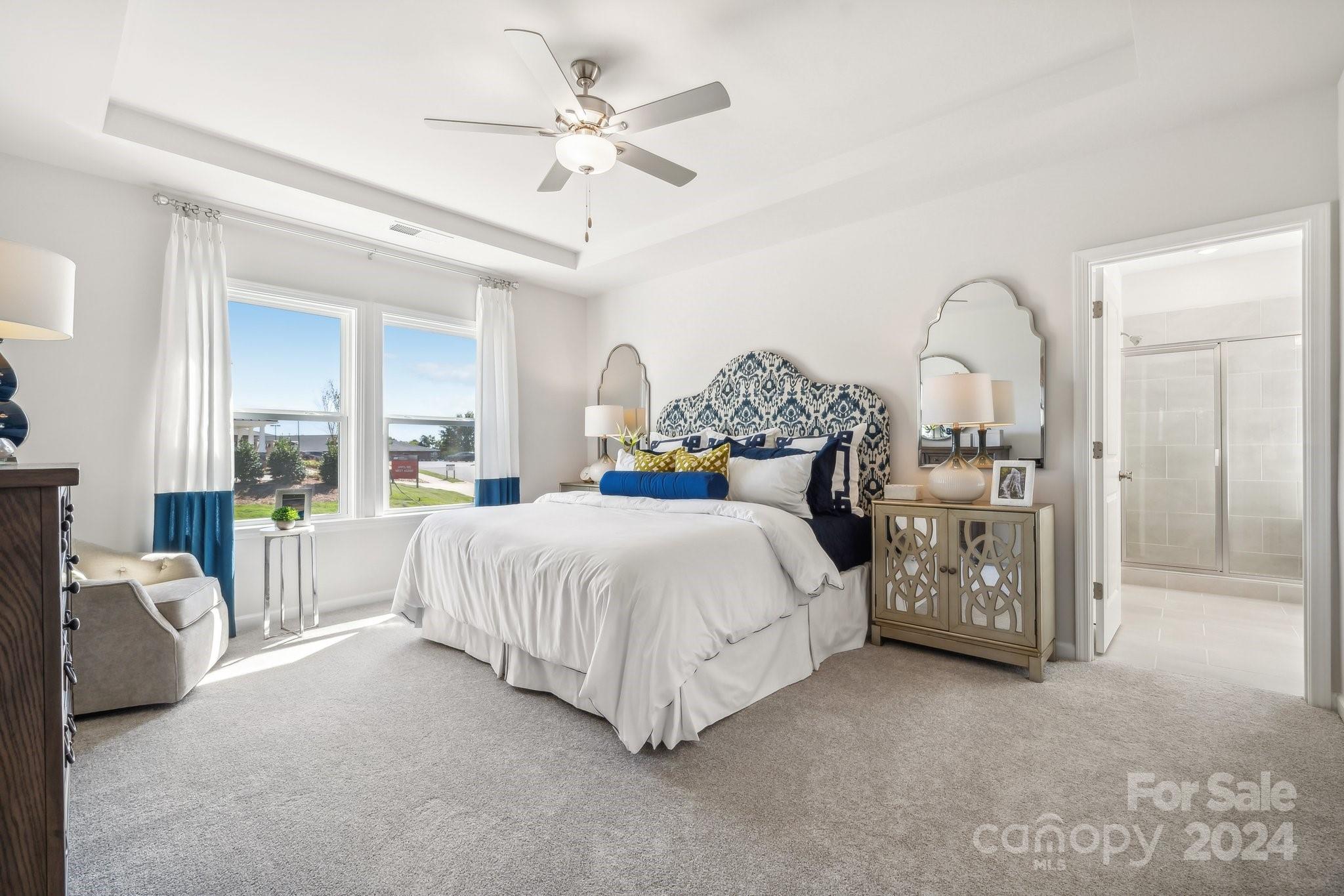 1406 Hubert Graham Way Tega Cay, SC 29708 - Photo 14 of 26 a spacious bedroom with a bed a chandelier and a large window