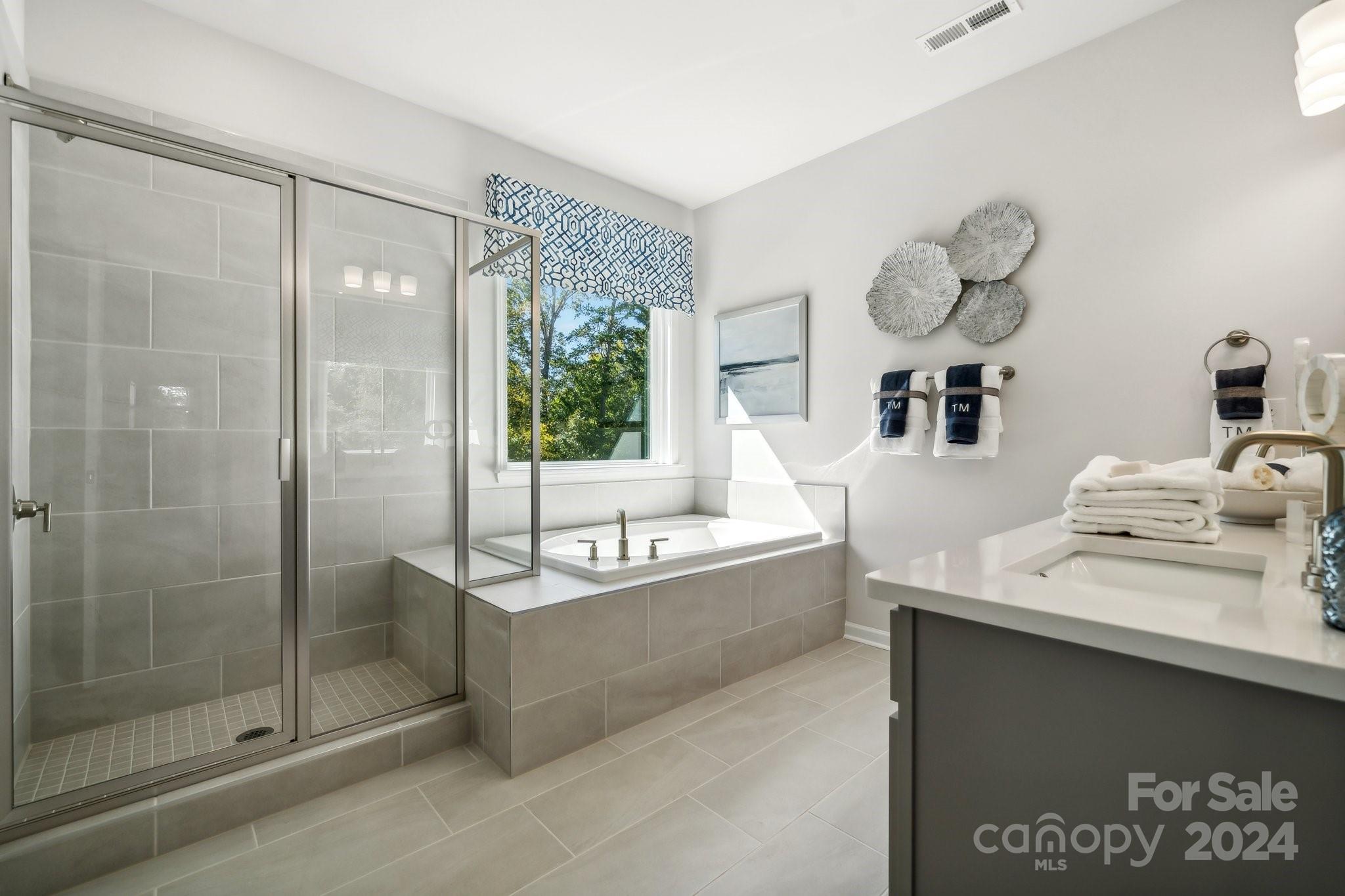 1406 Hubert Graham Way Tega Cay, SC 29708 - Photo 15 of 26 a bathroom with a tub sink and mirror