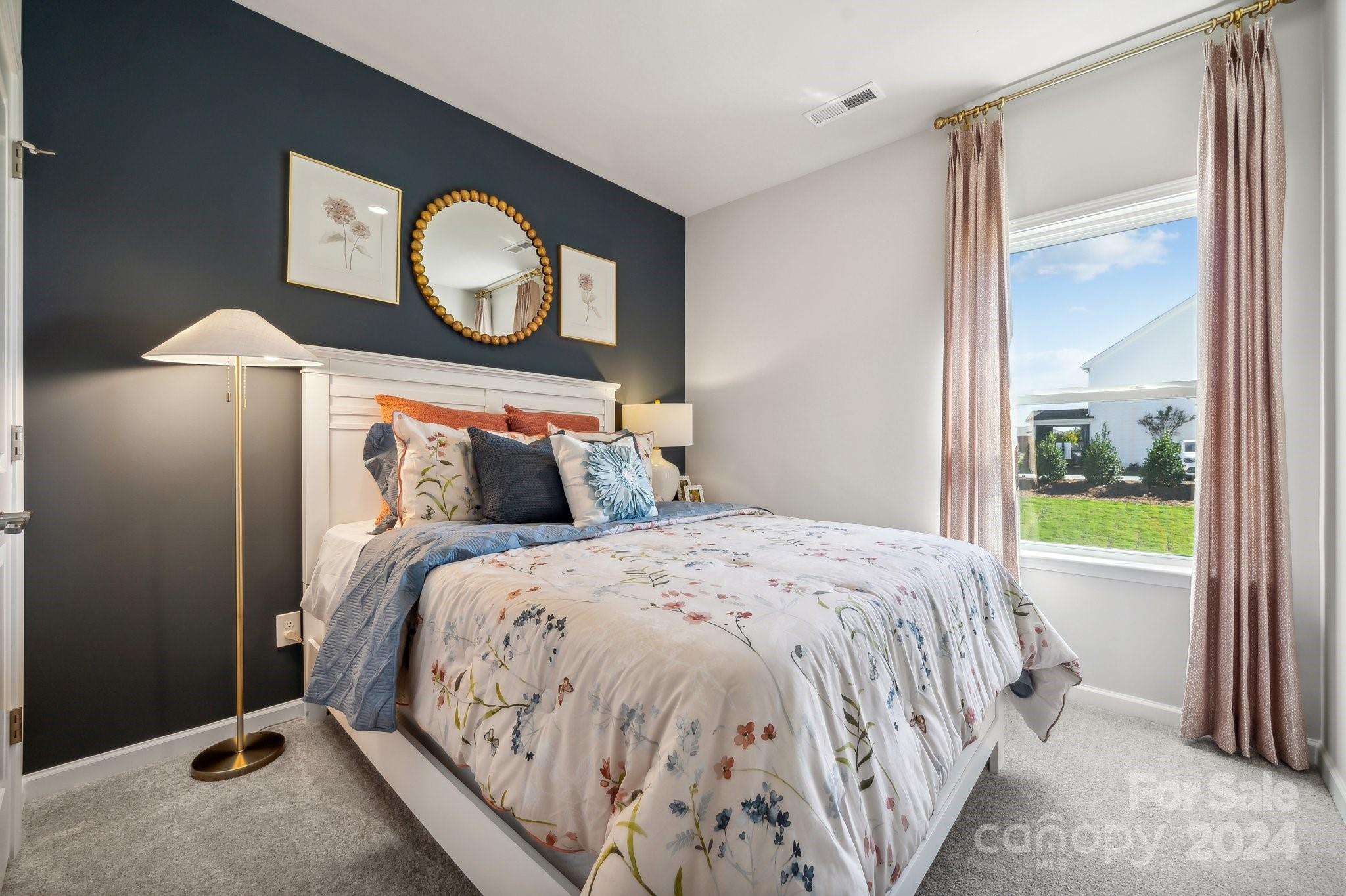 1406 Hubert Graham Way Tega Cay, SC 29708 - Photo 17 of 26 a bed sitting in a bedroom next to a window
