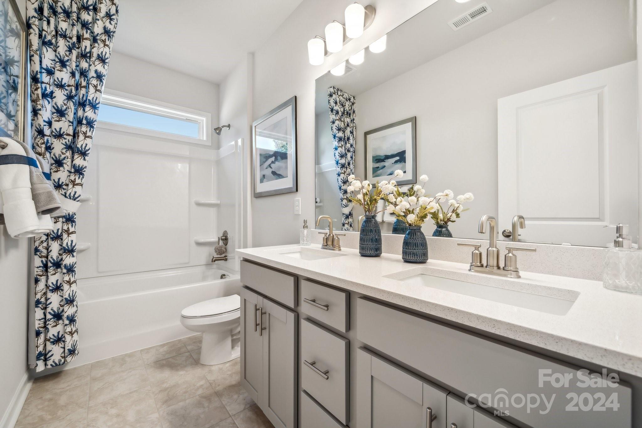 1406 Hubert Graham Way Tega Cay, SC 29708 - Photo 18 of 26 a bathroom with a bathtub a sink and a large mirror