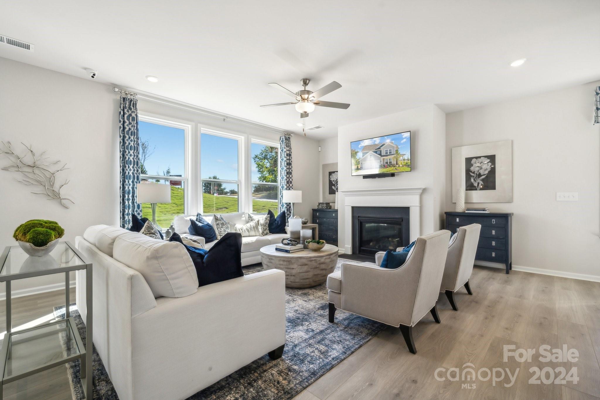 1406 Hubert Graham Way Tega Cay, SC 29708 - Photo 7 of 26 a living room with furniture a fireplace and a large window