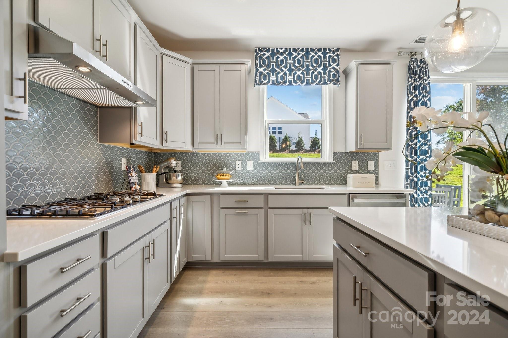 1406 Hubert Graham Way Tega Cay, SC 29708 - Photo 10 of 26 a kitchen with a sink dishwasher a stove and white cabinets