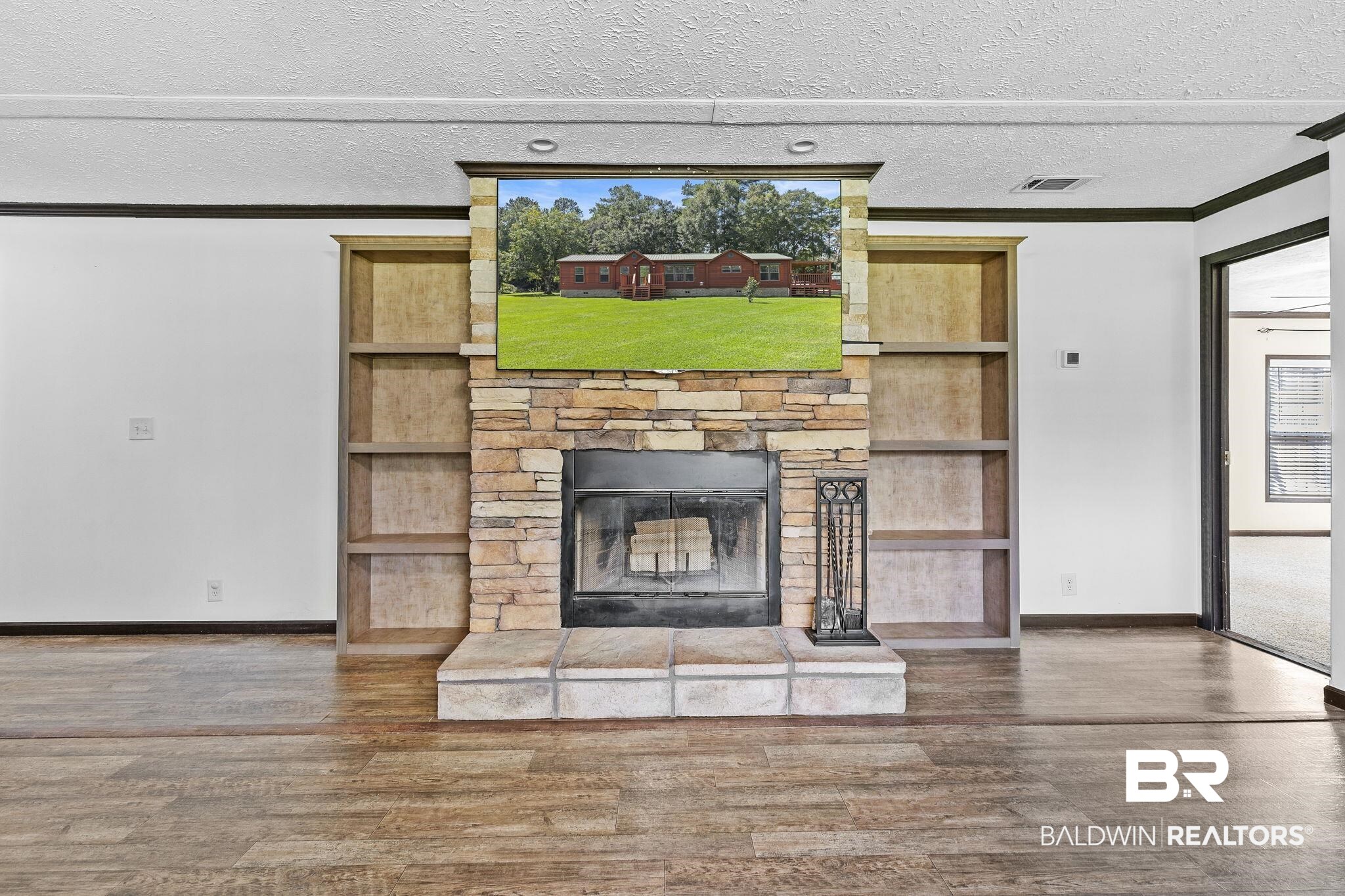 35641 County Road 39 Stapleton, AL 36578 - Photo 13 of 46 Unfurnished living room featuring ornamental molding, a textured ceiling, a fireplace, and dark hardwood / wood-style flooring