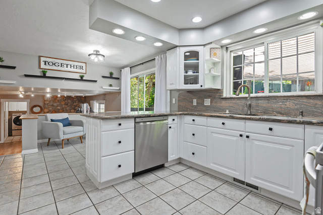 3310 Creek Road Salt Lake City, UT 84121 - Photo 17 of 49 Kitchen featuring white cabinetry with black hardware, granite countertops, stainless steel dishwasher, recessed lighting, and tile flooring