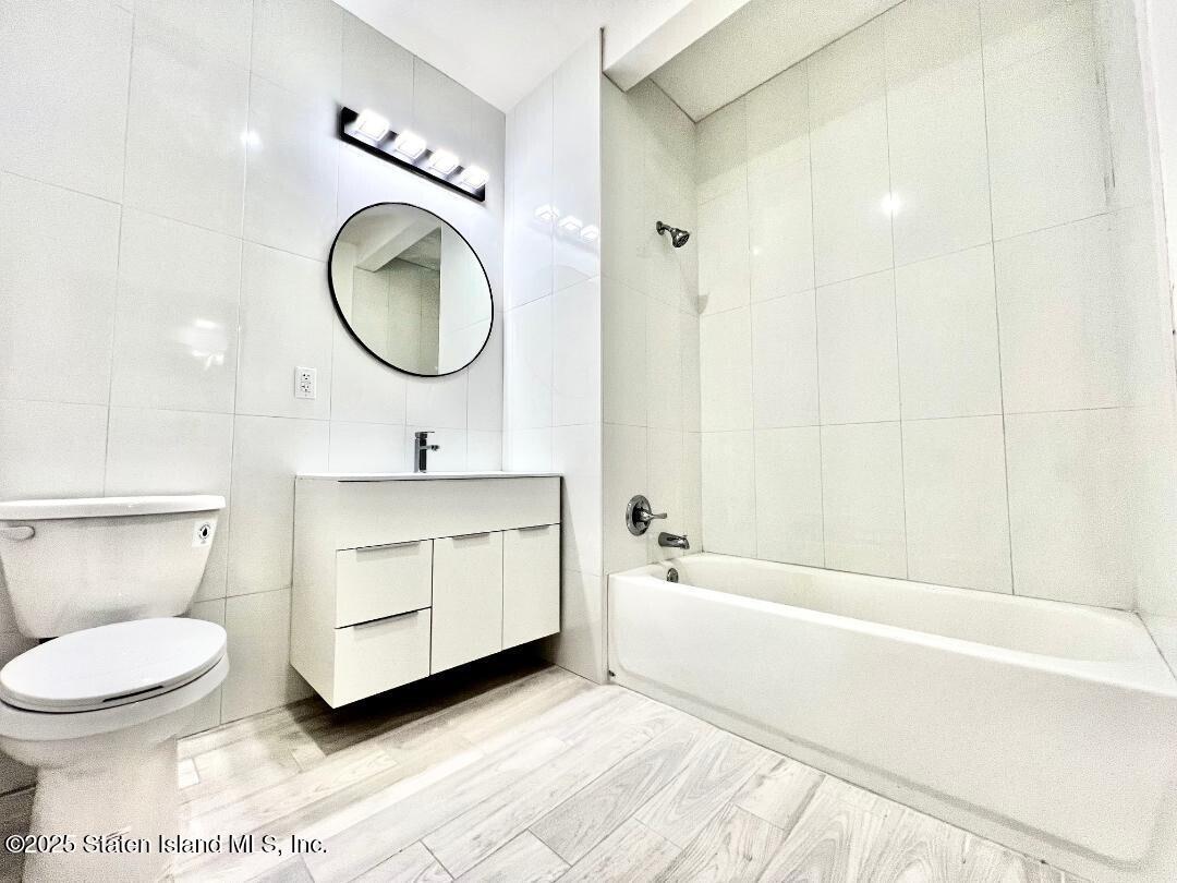 3865 Amboy Road, Unit 3F Staten Island, NY 10308 - Photo 13 of 20 a bathroom with a toilet a sink a mirror and bathtub