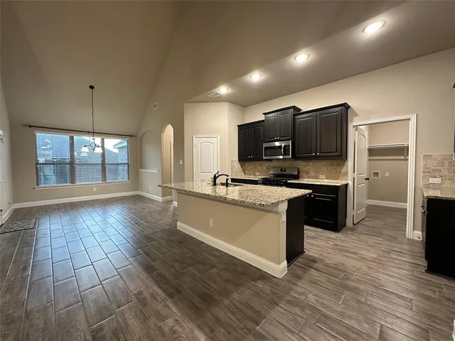 a large kitchen with hardwood floor and a window