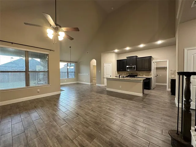 a view of kitchen with microwave a refrigerator and cabinets