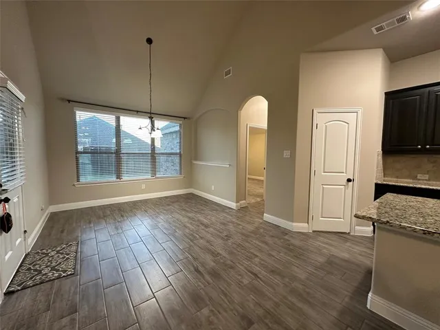 a view of a kitchen with wooden floor and a window