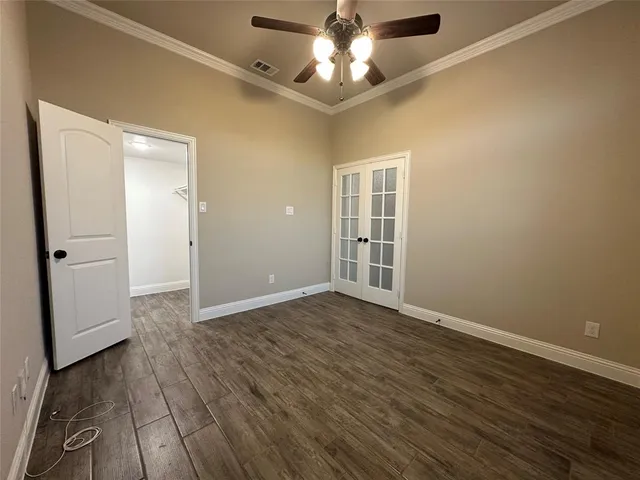 an empty room with closet and a chandelier fan