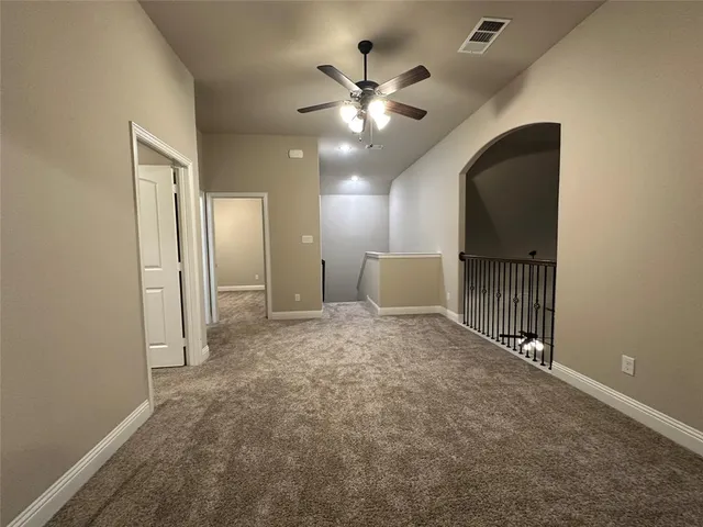 an empty room with closet and a chandelier fan