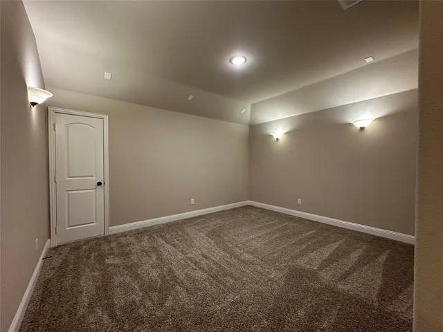 an empty room with a chandelier fan and windows