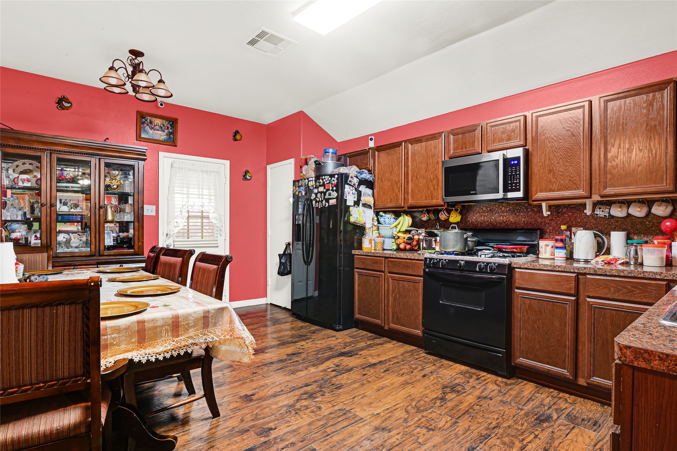 2902 Back Bay Brook Trail Houston, TX 77045 - Photo 11 of 20 a kitchen with stainless steel appliances kitchen island granite countertop a sink dishwasher a dining table and chairs with wooden floor