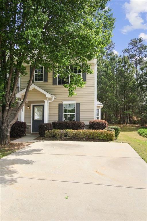a front view of a house with yard and trees