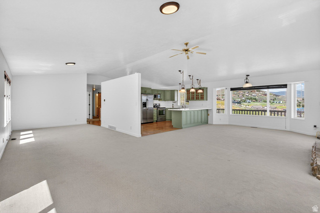 380 Luzern Road Midway, UT 84049 - Photo 15 of 74 Expansive great room featuring light-colored carpet flooring, white walls, and a ceiling fan