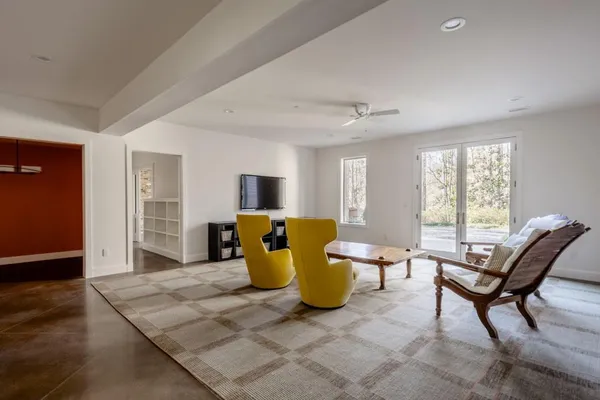 a living room with furniture a window and a flat screen tv