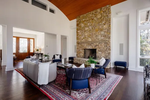 a living room with furniture a fireplace and wooden floor