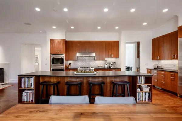 a kitchen with stainless steel appliances granite countertop a stove top oven a sink dishwasher and cabinets with wooden floor