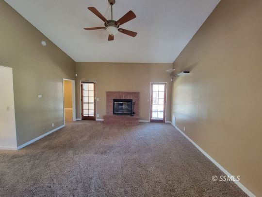 218 Kennedy Court Ridgecrest, CA 93555 - Photo 9 of 19 an empty room with fireplace and windows