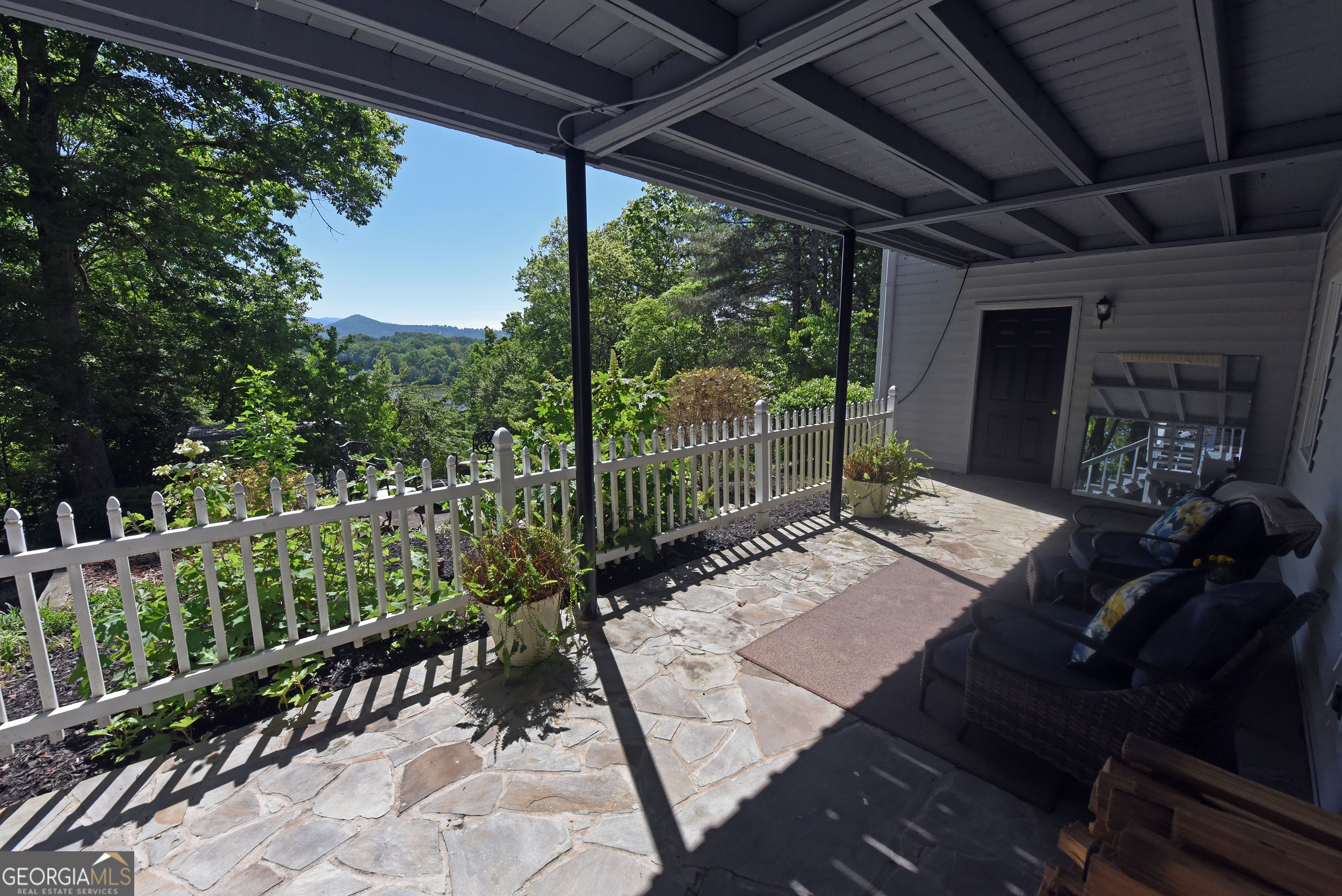 382 Pat Colwell Road, Unit TRACT 1 Blairsville, GA 30512 - Photo 41 of 43 a view of a patio with table and chairs potted plants with floor to ceiling window and wooden fence