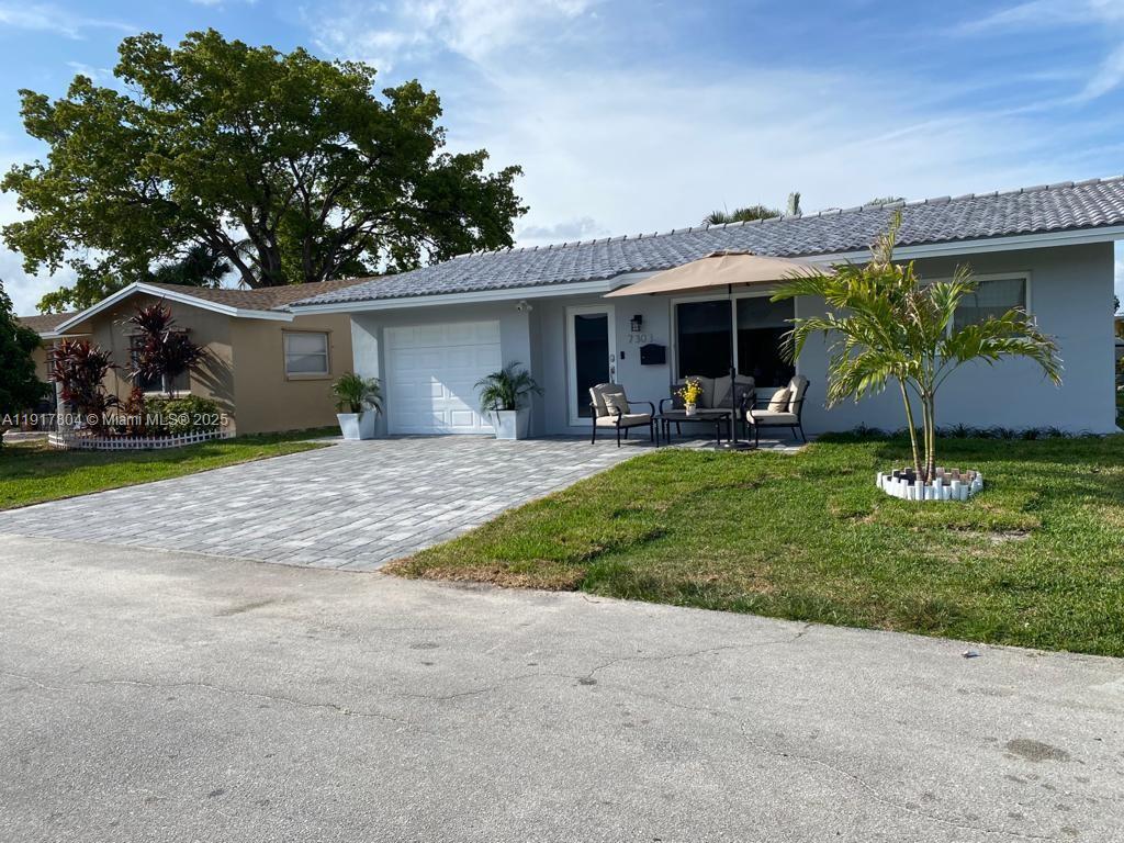 7303 Northwest 57th Drive, Unit 7303 Tamarac, FL 33321 - Photo 2 of 15 a front view of a house with garden
