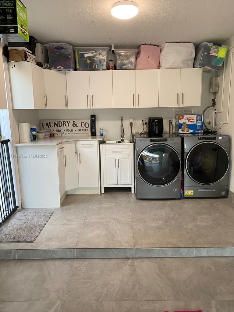 7303 Northwest 57th Drive, Unit 7303 Tamarac, FL 33321 - Photo 4 of 15 a kitchen with a stove cabinets and a sink
