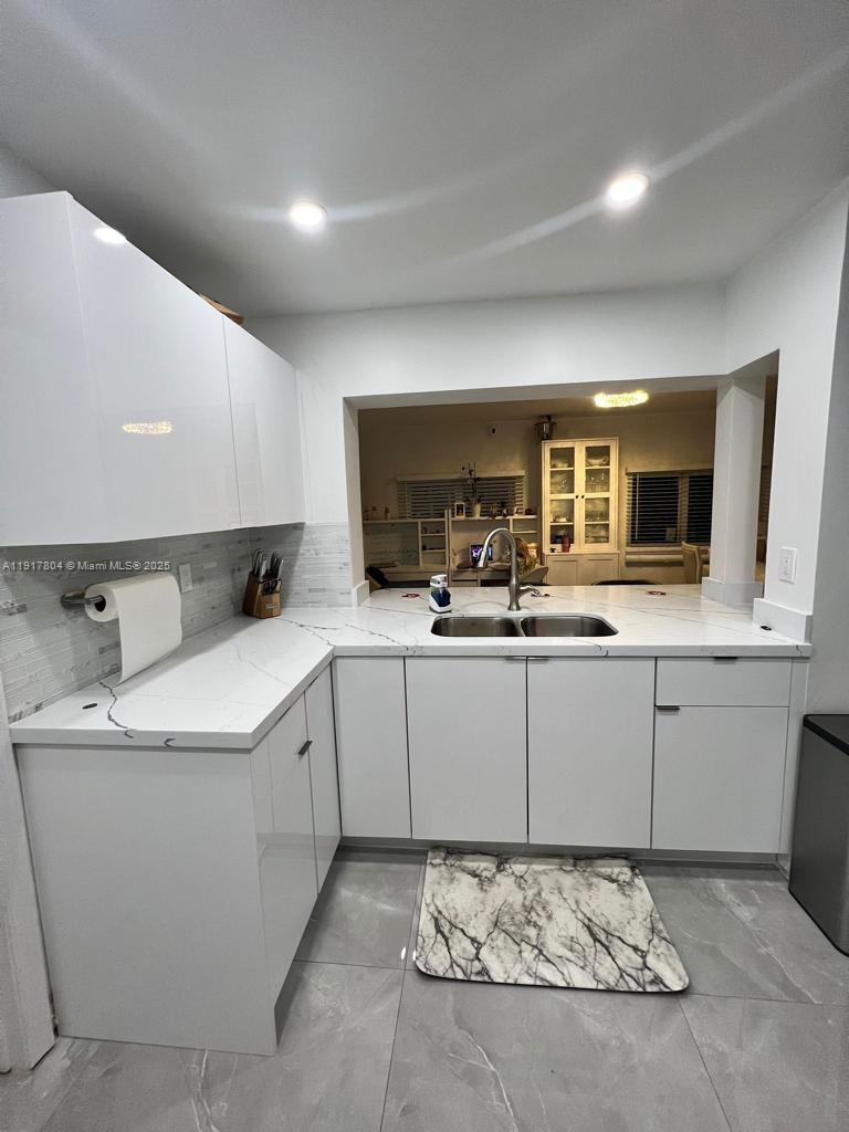 7303 Northwest 57th Drive, Unit 7303 Tamarac, FL 33321 - Photo 5 of 15 a kitchen with a sink and cabinets