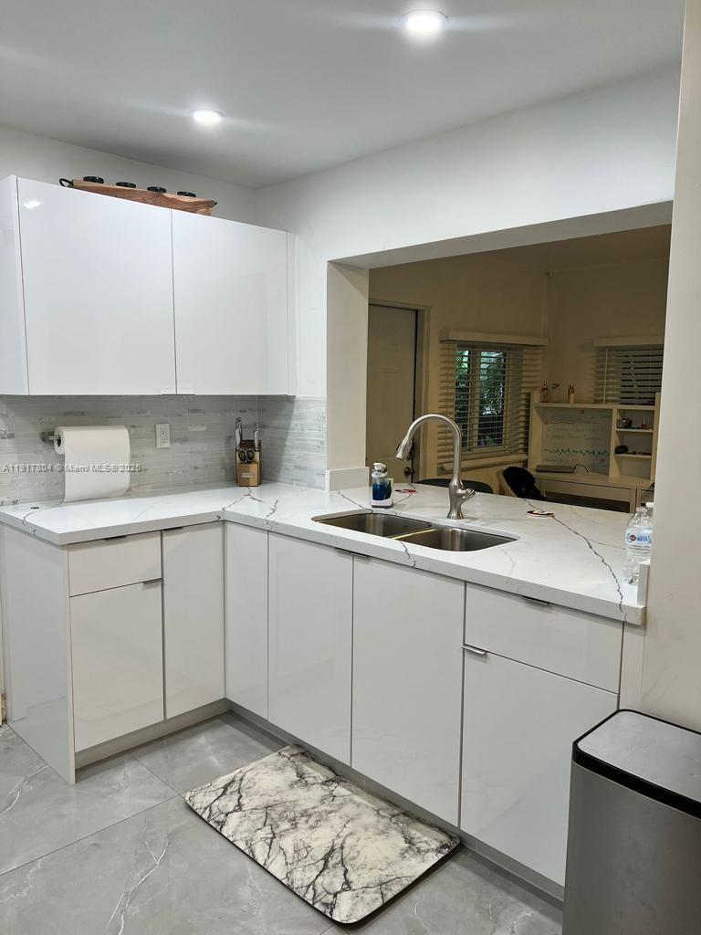 7303 Northwest 57th Drive, Unit 7303 Tamarac, FL 33321 - Photo 6 of 15 a kitchen with a sink cabinets and window