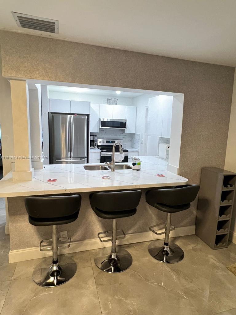 7303 Northwest 57th Drive, Unit 7303 Tamarac, FL 33321 - Photo 7 of 15 a living room with a couch and a table