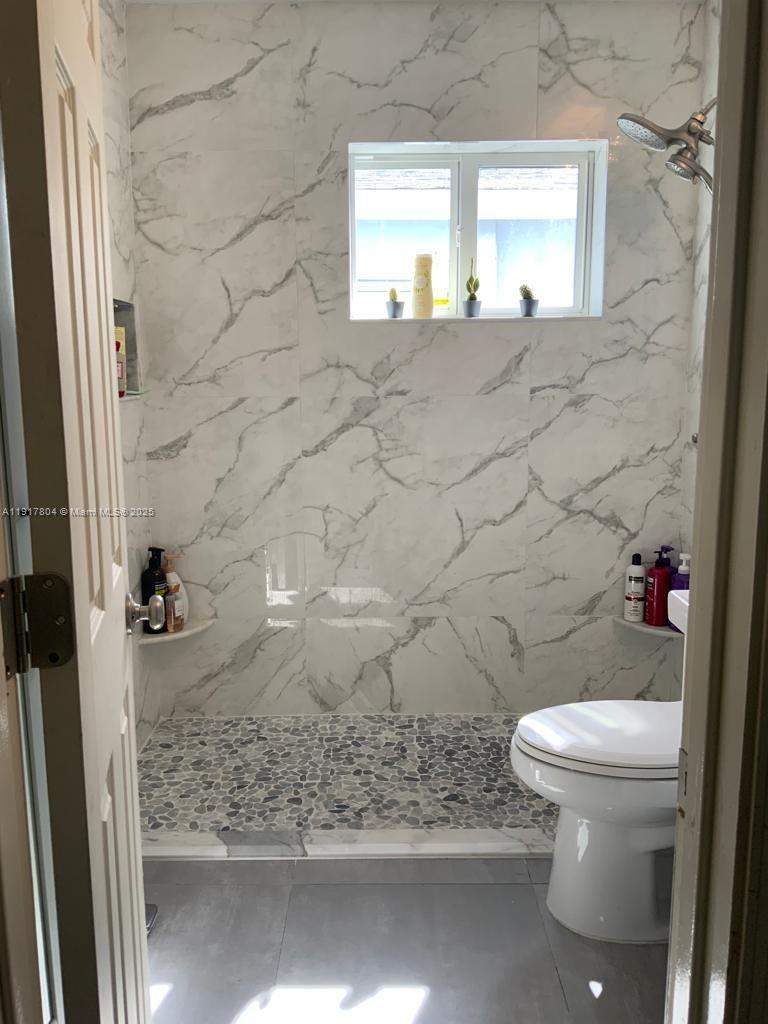 7303 Northwest 57th Drive, Unit 7303 Tamarac, FL 33321 - Photo 10 of 15 a bathroom with a toilet and a shower