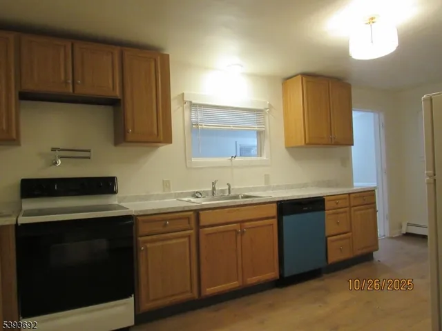 a view of a refrigerator in kitchen and a sink