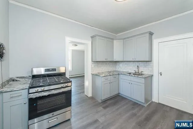 a kitchen with granite countertop white cabinets and stainless steel appliances
