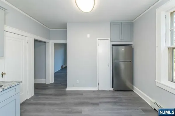 a view of empty room with wooden floor and window