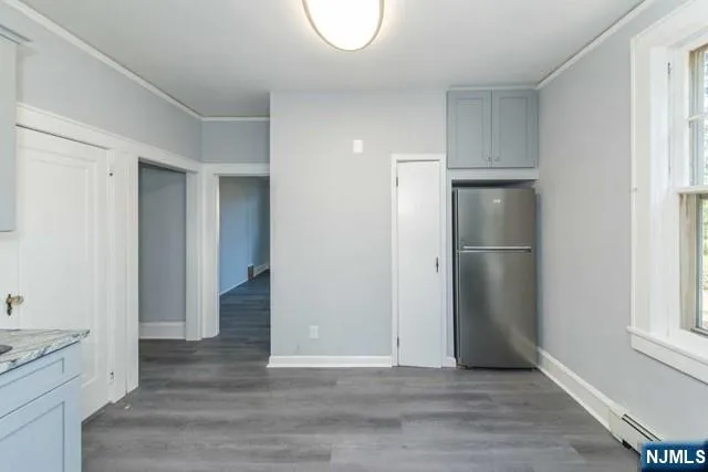 a view of empty room with wooden floor and window