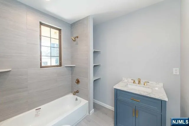 a bathroom with a bathtub sink and mirror