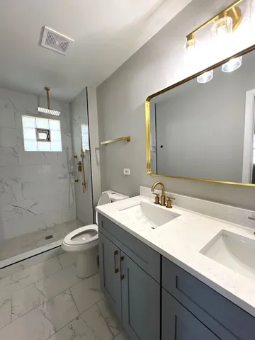 a bathroom with a sink a toilet and shower