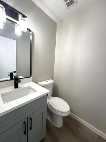 a bathroom with a sink vanity mirror and toilet