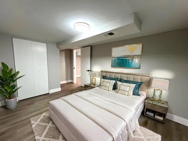 a bedroom with a large bed and a potted plant