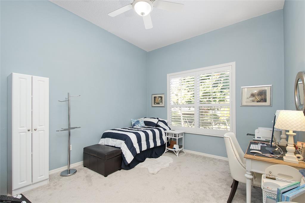 2808 Falcon Ridge Clermont, FL 34711 - Photo 11 of 65 a bedroom with a bed lamps and a large mirror