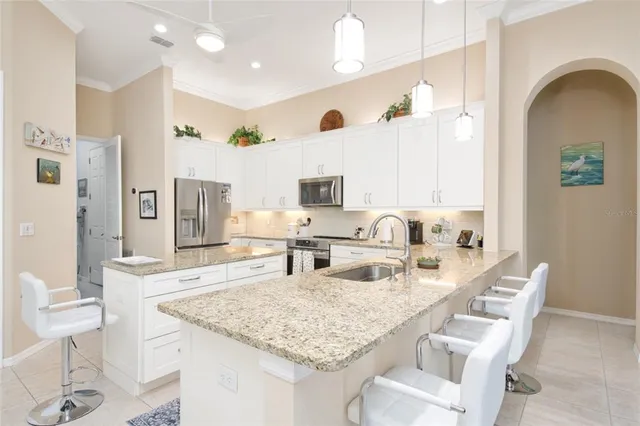 a view of a dining room with furniture a chandelier and large windows
