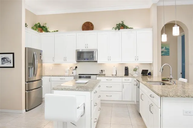 a kitchen with kitchen island granite countertop a sink a center island stainless steel appliances and cabinets