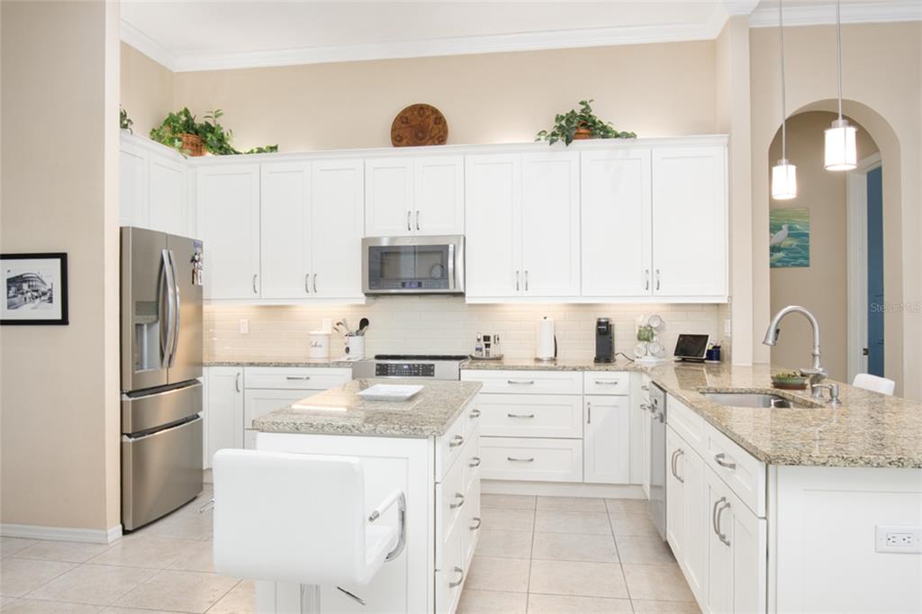 2808 Falcon Ridge Clermont, FL 34711 - Photo 3 of 65 a kitchen with kitchen island granite countertop a sink a center island stainless steel appliances and cabinets