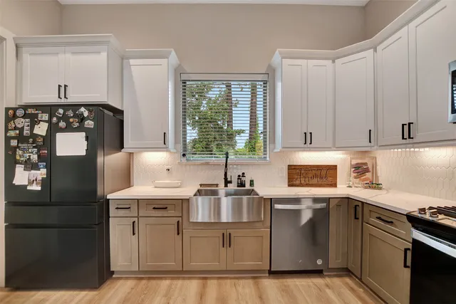 a bedroom with a large bed chandelier and a window