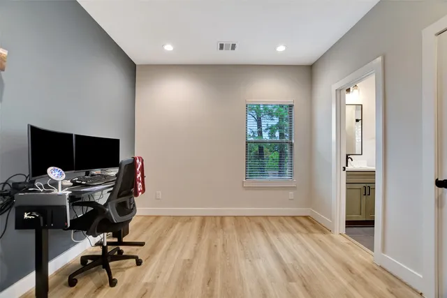 a view of a hallway with wooden floor and chair