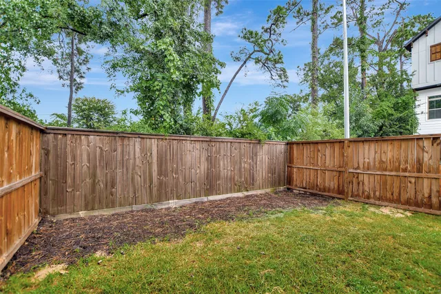 a view of a brick house with wooden fence