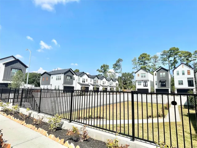 a view of a house with a yard and wooden fence